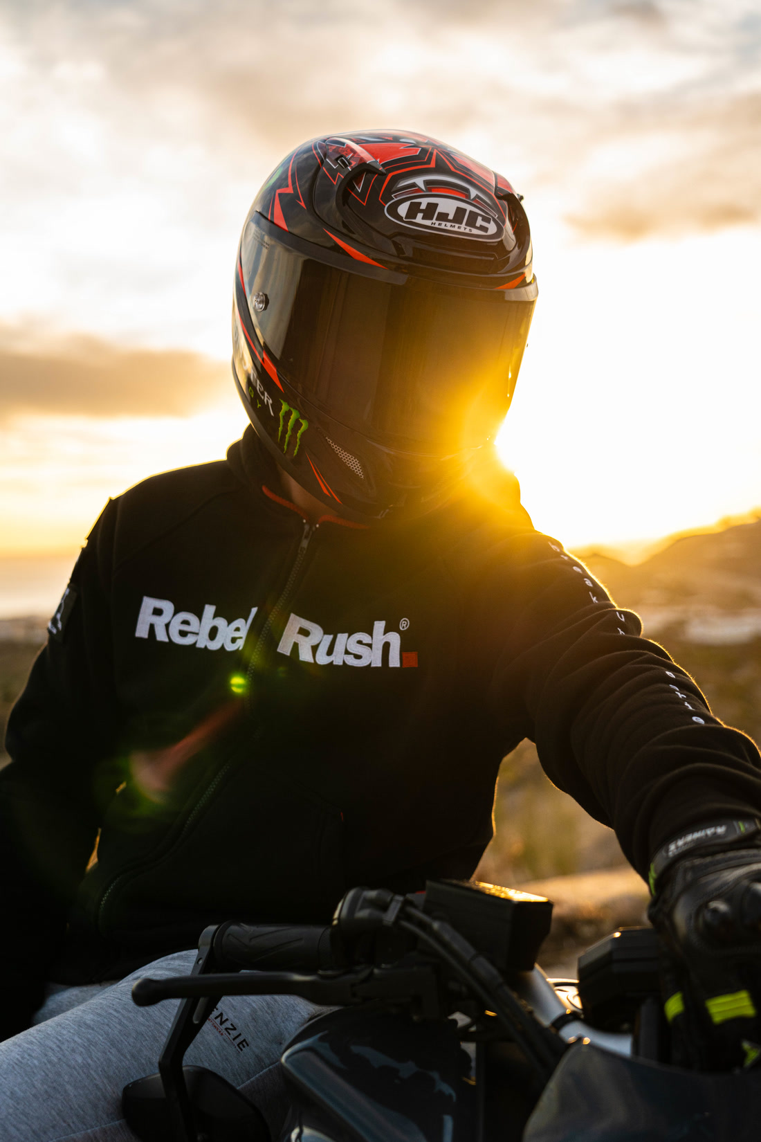 Motorista con casco a contraluz al atardecer